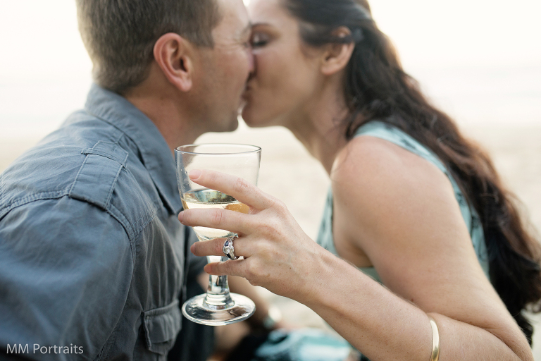 wine glass with couple kissing out of focus behind. 