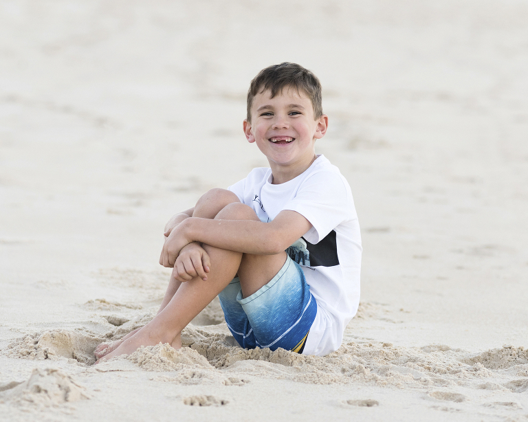 a boy with a big smile on the beach