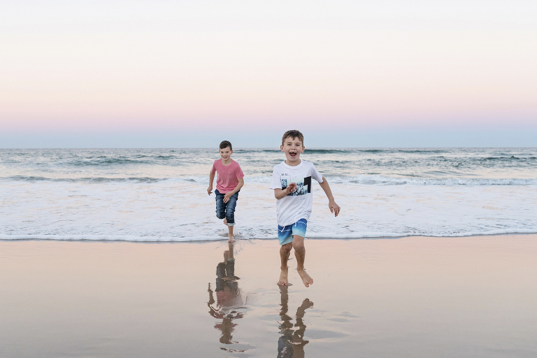 boys chasing each other on the beach