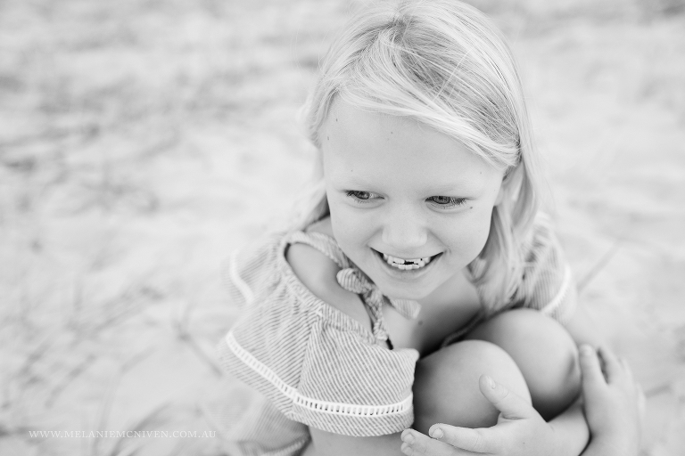 young girl sitting at beach