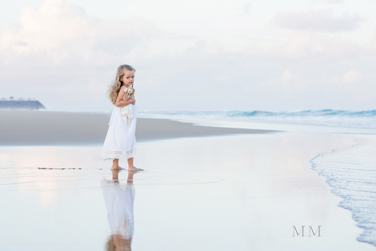 girl on beach walking with doll